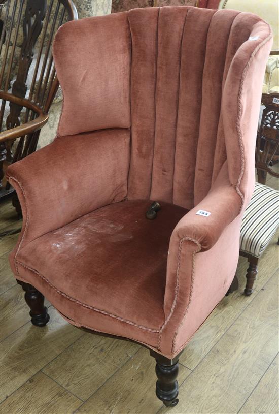A barrel back upholstery armchair, castors off